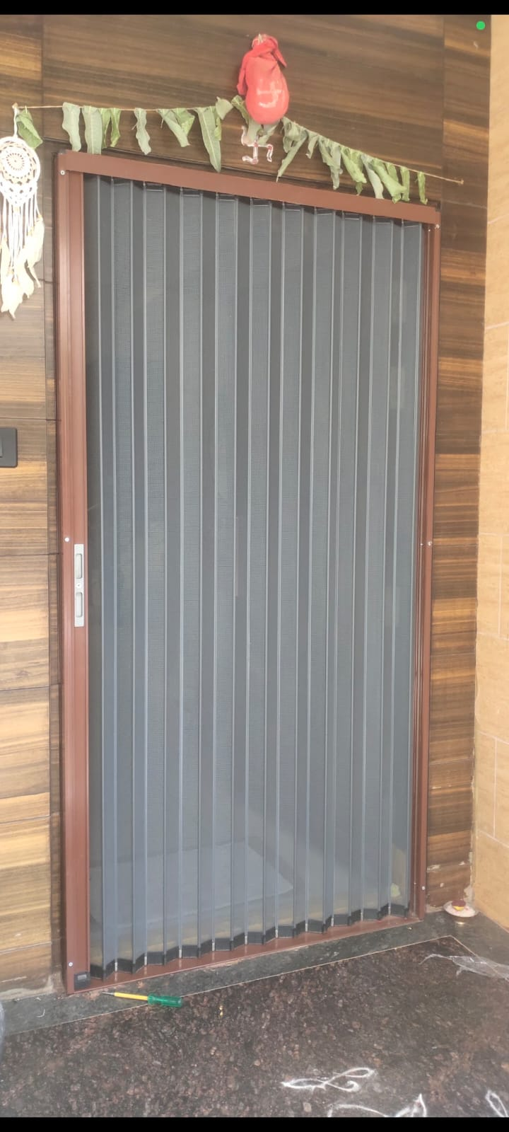 Brown-framed pleated mesh screen door